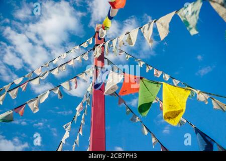 Le bandiere tibetane pendono su una corda contro il cielo Foto Stock