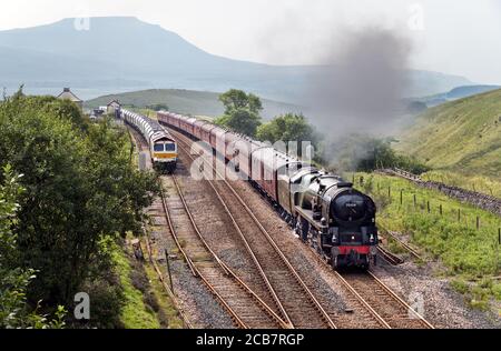 "Il Dalesman" vapore speciale sulla linea ferroviaria Settle-Carlisle, visto qui nel Parco Nazionale delle Valli dello Yorkshire, passando Blea Moor segnale box e un treno fisso di cava nel siding. Il treno è normalmente una caratteristica regolare nei mesi estivi, ma le runings sono state più limitate a causa di Covid-19. Il treno di oggi era diretto a Carlisle tramite la linea Settle-Carlisle, ritornando a sud attraverso la linea principale della costa occidentale Shap. Il treno è stato trasportato dalla locomotiva a vapore d'epoca degli anni '40 "British India Line". Il servizio è gestito dalla West Coast Railways. Credit: John Bentley/Alamy Live News Foto Stock