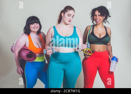 Più le donne di taglia che fanno sport e fitness. Ritratti di studio con ragazze multietniche curvy Foto Stock