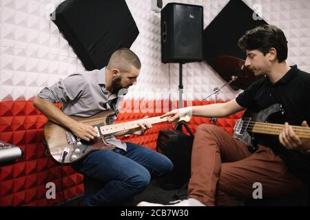 Musicisti seduti in camera insonorizzata con altoparlanti Foto Stock