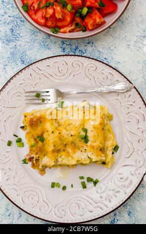 Un pezzo di lasagna appena sfornata con una crosta tostata su una piastra Foto Stock