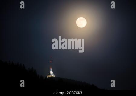 Luna piena sopra Jested, sulla città di Liberec, repubblica Ceca. Gestato. Vista dal Virive pietre Jested Mountain. Montagne Jizerske e Liberec. Foto Stock