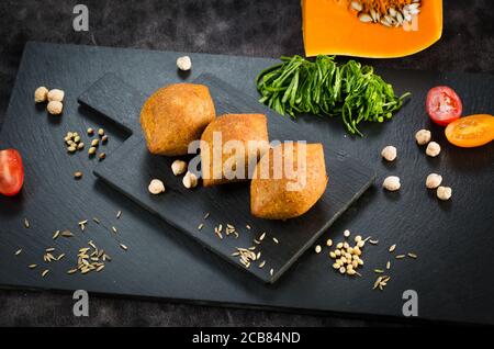 Tradizionale kibbeh arabo-turco-siiriano con agnello e pinoli. Vista dall'alto. Sfondo in legno naturale Foto Stock