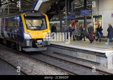 I passeggeri che arrivano e partono da un treno New Northern CAF Civity 331 classe trenino elettrico a più unità a Leeds Stazione ferroviaria Foto Stock