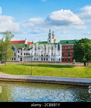 Paesaggio urbano soleggiato con torri di chiesa e architettura della città vecchia dal fiume Svisloch a Minsk, Bielorussia Foto Stock