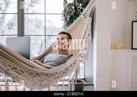 Giovane freelance caucasico in cuffia funziona su un computer portatile, naviga in Internet Foto Stock