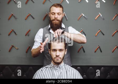Barbiere con forbici e pettine. Concetto di Servizio di cura dei capelli Foto Stock