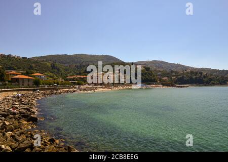 Vista panoramica della baia con rocce e spiaggia sabbiosa sulla riva del Golfo dei Poeti e le colline boscose in estate, Lerici, Liguria, Italia Foto Stock