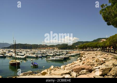 Vista del porto sulla riva del Golfo dei Poeti con barche da pesca ancorate in una soleggiata giornata estiva, Lerici, la Spezia, Liguria, Italia Foto Stock