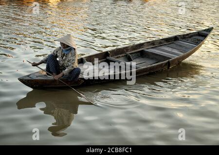 Donna su una barca di legno a Hoi An, Vietnam Foto Stock