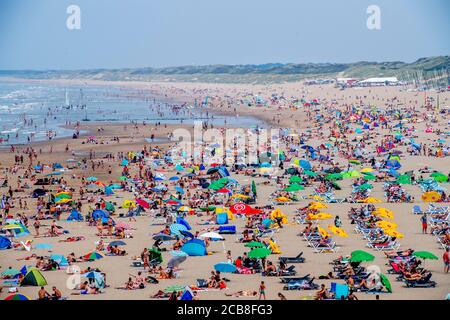 Le persone affollate in spiaggia durante l'onda di calore.la spiaggia è piena e piena di impegni mentre le persone si rinfrescano godendo il bel tempo caldo durante l'onda di calore nelle temperature tropicali estive. Foto Stock