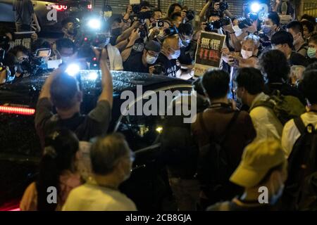 Hong Kong, Cina. 12 agosto 2020. Sostenitori pro-democrazia che tengono i quotidiani Apple al di fuori della stazione di polizia di Mongkok come magnate dei media pro-democrazia di Hong Kong e fondatore di Apple Daily Jimmy Lai, Che è stato arrestato lunedì in base alla nuova legge nazionale sulla sicurezza, lascia la stazione di polizia di Mong Kok dopo essere stato rilasciato in carcere all'inizio di martedì 12 agosto 2020 a Hong Kong, Cina. Secondo la polizia locale, Lai è stato arrestato per sospetto di 'collusione con potenze straniere. Credit: May James/ZUMA Wire/Alamy Live News Foto Stock