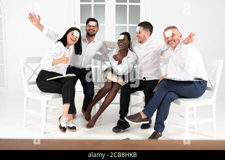 Piccolo adesivo sul fronte. Divertirsi in ufficio. Gentili colleghi giocare intorno e celebrare il successo Foto Stock