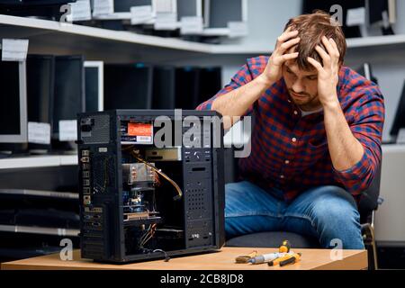 oh, il mio Dio.frustrato giovane uomo a causa di rotto sistema unit.closeup ritratto. Depressione concetto Foto Stock