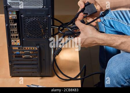 uomo che tiene i fili fissi, ragazzo che cerca di districare i fili . primo piano vista laterale ritaglio foto Foto Stock