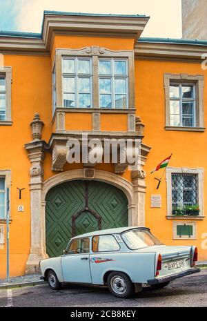 Budapest, Ungheria, ago 2019, vista di una Trabant auto parcheggiata di fronte a un edificio color ocra Foto Stock