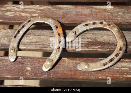 Ferro di cavallo arrugginito su un tavolo di legno Foto Stock