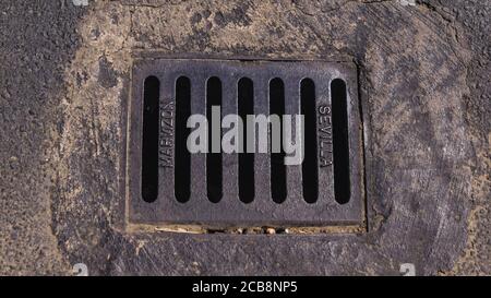 copertura del canale di ferro tra il pavimento in cemento Foto Stock