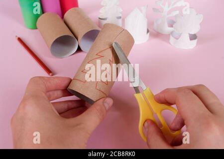 Come fare alberi, decorazione. Attività quotidiane, fai da te per i bambini, zero sprechi, giocattoli ecologici fatti a mano da rotolo di carta. in 3 fasi, prendere le forbici. Foto Stock