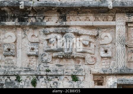 Sculture precolombiane sulle pareti di uno degli edifici del sito Maya Chichen-Itza, Messico. Foto Stock