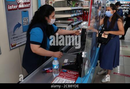 Ankara, Turchia. 11 Agosto 2020. Un cassiere controlla gli articoli di un cliente in un supermercato ad Ankara, Turchia, il 11 agosto 2020. La Turchia ha confermato 1,183 nuovi casi COVID-19 martedì, portando il totale dei casi diagnosticati a 243,180, ha detto il ministro della Sanità turco Fahrettin Koca. Credit: Mustafa Kaya/Xinhua/Alamy Live News Foto Stock