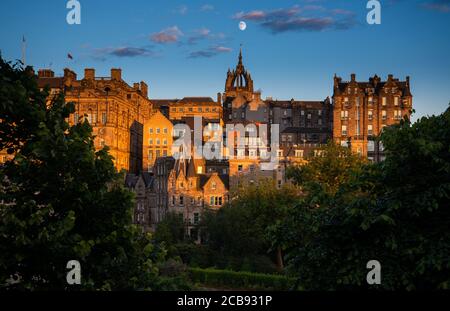 Città vecchia di Edimburgo con la cattedrale di St Giles e una luna in ascesa vista da Princes Street Foto Stock