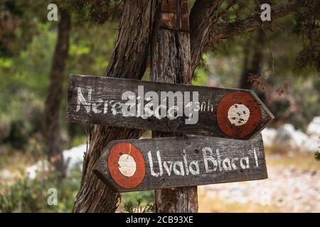 Cartello in legno che mostra la strada per la Pustinja Blaca, area desertica dell'isola di Brac in croazia Foto Stock