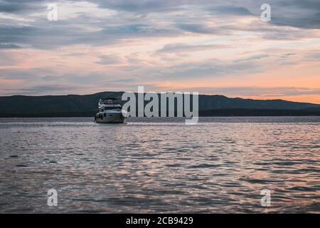 Yacht ancorato vicino al Rat Zlatni, famosa spiaggia nella città di Bol. Tramonto sul mare Adriatico Foto Stock