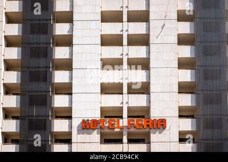 La facciata pulita di un edificio abbandonato con finestre rotte durante il giorno, con linee semplici. Foto Stock
