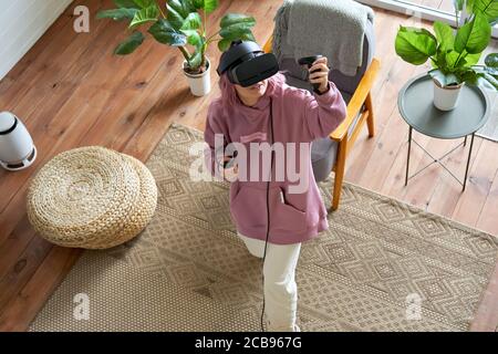 Teen girl indossare occhiali di protezione vr esplorare la realtà virtuale guardando in alto vista. Foto Stock