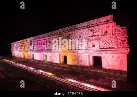 L'edificio ovest del Nunnery Quadrangle è illuminato da luci colorate nelle rovine maya pre-ispaniche di Uxmal, Messico. Foto Stock