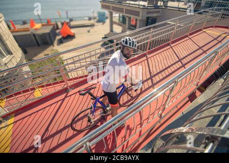 Sorridente ciclista che guarda in su con la testa in su Foto Stock