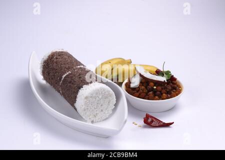 Ragi Puttu o Millet Puttu, colazione kerala fatta in casa Usando il miglio del dito e cocco essiccato, cibo indiano sano messo sopra una tavola bianca Foto Stock