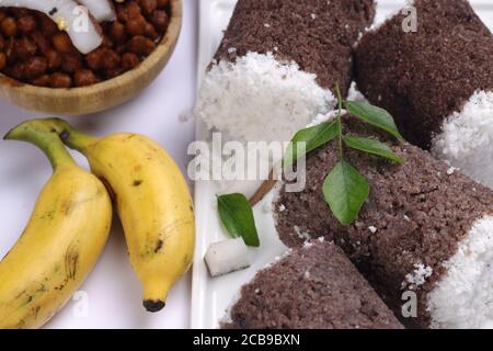 Ragi Puttu o Millet Puttu, colazione kerala fatta in casa Usando il miglio di dito e cocco essiccato, cibo indiano messo su un stoviglie bianche con ka Foto Stock