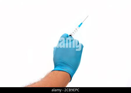 Mano dell'uomo in guanto di lattice blu con siringa di plastica isolata su sfondo bianco. Concetto medico Foto Stock