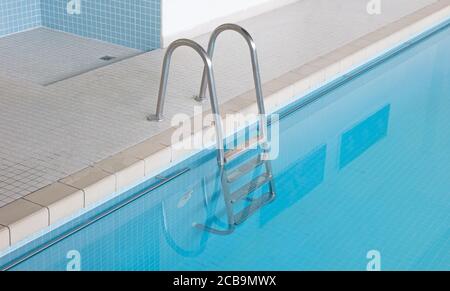 Scale metalliche in una piscina interna Foto Stock