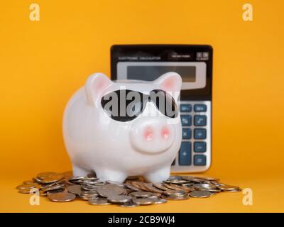 conservazione del capitale in una crisi economica calcolatrice monete di fondo giallo Foto Stock