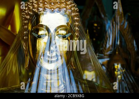 primo piano della testa della statua di buddha, nel tempio buddista, di colore dorato Foto Stock