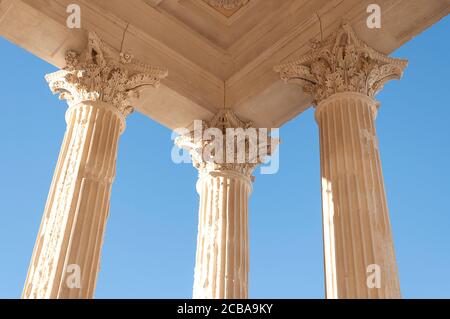 Dettaglio di tre colonne in stile corinzio della Maison Carree, uno dei templi romani meglio conservati, situato a Nimes, nel sud della Francia. Foto Stock