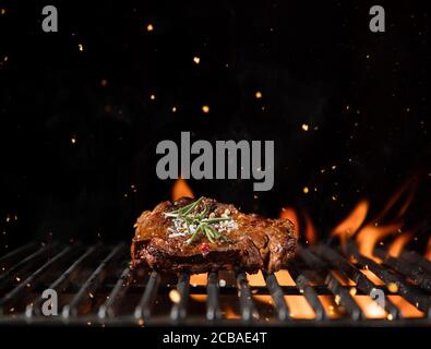 Fiery griglia grill con un pezzo di carne di manzo. Spazio libero per il testo Foto Stock