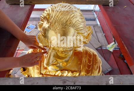 Dresda, Germania. 12 agosto 2020. Anna-Maria Schuch-Baensch, restauratrice della società Fuchs und Girke, sta lavorando alla nuova doratura durante il restauro del Golden Rider. La statua equestre più grande della vita dell'Elettore sassone Agosto il forte (1670-1733), l'Orsemano d'Oro, dal 18 ° secolo riceverà un trattamento di bellezza di 30,000 euro entro la fine di settembre. Questo riparerà i danni lasciati dietro da uccelli, vento, polvere, acqua piovana e le temperature e l'attacco con un liquido caustico nel 2017. Credit: Robert Michael/dpa-Zentralbild/dpa/Alamy Live News Foto Stock