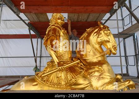 Dresda, Germania. 12 agosto 2020. Horst Pötzschke, doratrice della società Fuchs und Girke, lavora alla nuova doratura durante il restauro del Golden Rider. La statua equestre più grande della vita dell'Elettore sassone Agosto il forte (1670-1733), l'Orsemano d'Oro, dal 18 ° secolo riceverà un trattamento di bellezza di 30,000 euro entro la fine di settembre. Questo riparerà i danni lasciati dietro da uccelli, vento, polvere, acqua piovana e le temperature e l'attacco con un liquido caustico nel 2017. Credit: Robert Michael/dpa-Zentralbild/dpa/Alamy Live News Foto Stock