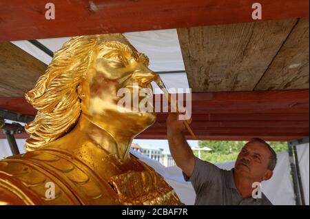 Dresda, Germania. 12 agosto 2020. Horst Pötzschke, doratrice della società Fuchs und Girke, lavora alla nuova doratura durante il restauro del Golden Rider. La statua equestre più grande della vita dell'Elettore sassone Agosto il forte (1670-1733), l'Orsemano d'Oro, dal 18 ° secolo riceverà un trattamento di bellezza di 30,000 euro entro la fine di settembre. Questo riparerà i danni lasciati dietro da uccelli, vento, polvere, acqua piovana e le temperature e l'attacco con un liquido caustico nel 2017. Credit: Robert Michael/dpa-Zentralbild/dpa/Alamy Live News Foto Stock