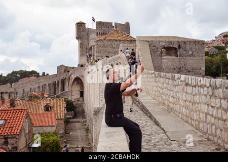 Dubrovnik / Croazia - 2 settembre 2019: turista scattare foto selfie con telefono sulla cima delle mura della fortezza Foto Stock