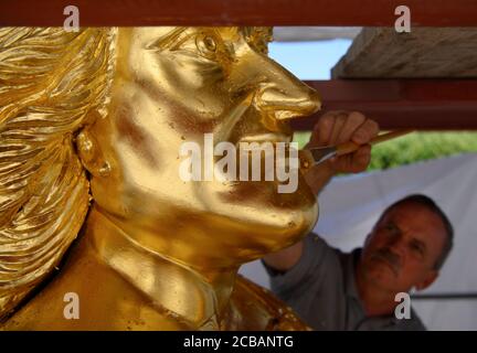 Dresda, Germania. 12 agosto 2020. Horst Pötzschke, doratrice della società Fuchs und Girke, lavora alla nuova doratura durante il restauro del Golden Rider. La statua equestre più grande della vita dell'Elettore sassone Agosto il forte (1670-1733), l'Orsemano d'Oro, dal 18 ° secolo riceverà un trattamento di bellezza di 30,000 euro entro la fine di settembre. Questo riparerà i danni lasciati dietro da uccelli, vento, polvere, acqua piovana e le temperature e l'attacco con un liquido caustico nel 2017. Credit: Robert Michael/dpa-Zentralbild/dpa/Alamy Live News Foto Stock