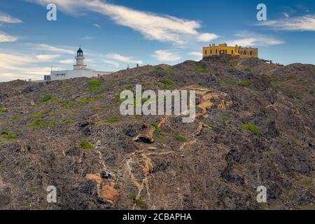 Vista del faro di Cap de Creus dalla baia di Culip nel parco geologico di Patge de Tudela, Cap de Creus, Catalogna, Spagna Foto Stock