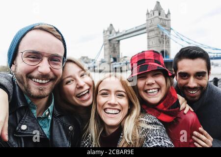 Amici felici che scattano foto selfie a londra con Tower Bridge In background - giovani che si divertono con le tendenze tecnologiche - Viaggi e amicizia c Foto Stock