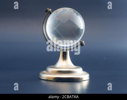 Globo bianco trasparente globo sfera isolata che si erge su metallo dorato cornice. Foto Stock
