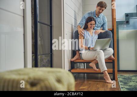 Giovane coppia che si rilassa a casa di lusso con il computer Foto Stock