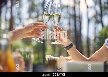 Bicchieri di vino in mani di bella coppia mentre hanno ottimo momento di relax Foto Stock